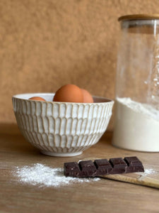 Bol Giwa artisanal coréen en grès blanc avec texture inspirée des tuiles traditionnelles, présenté avec des œufs, farine et chocolat.