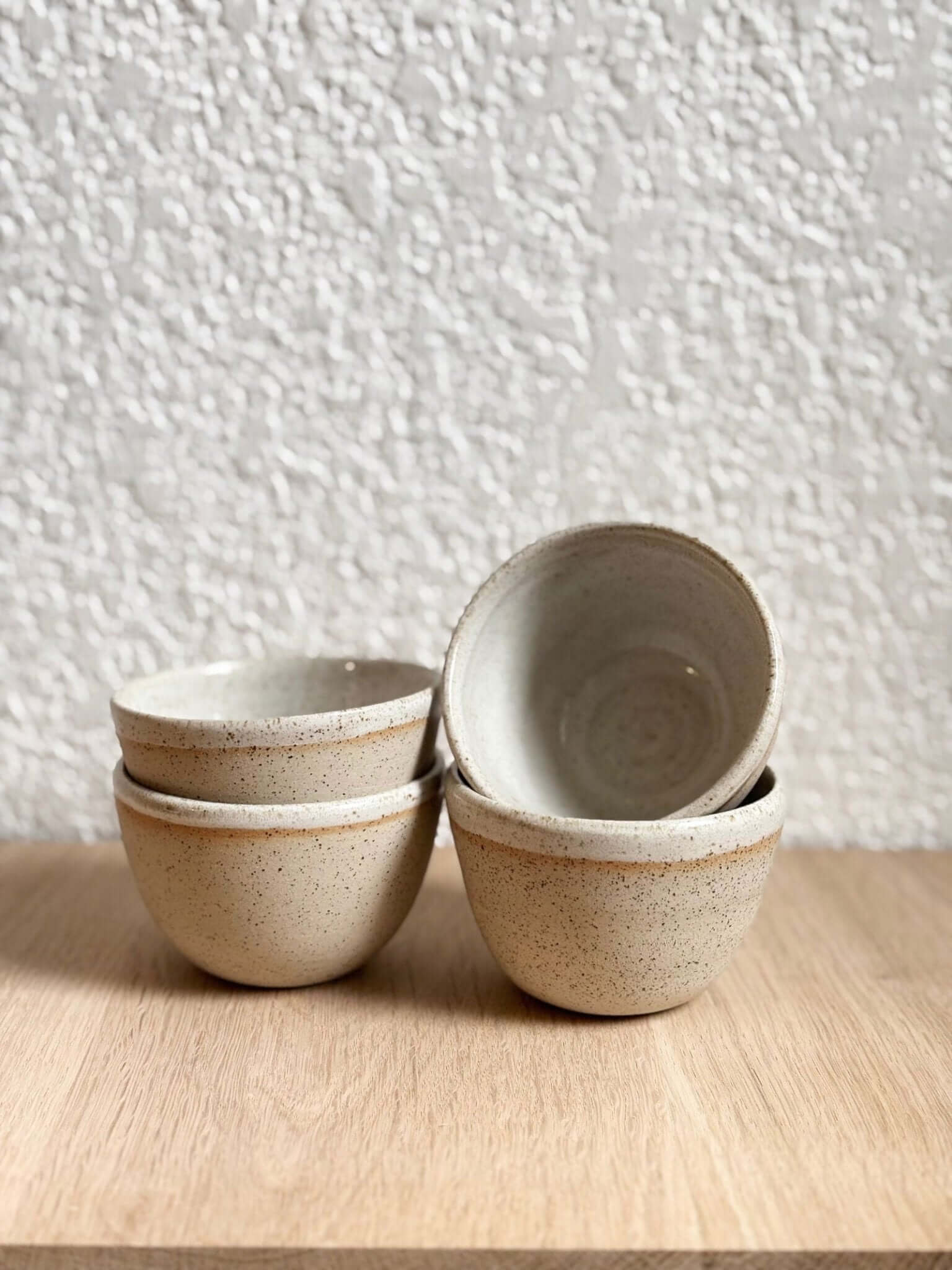 Ensemble de bols Petit Sabal Pyrite en grès pyrite, empilés sur une surface en bois, parfaits pour un usage quotidien ou des occasions spéciales.