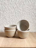 Ensemble de bols Petit Sabal Pyrite en grès pyrite, empilés sur une surface en bois, parfaits pour un usage quotidien ou des occasions spéciales.