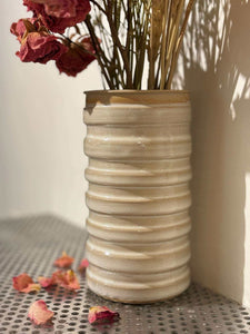 Vase Dolda en grès artisanal beige avec lignes ondulées, décoré de fleurs séchées, idéal pour la décoration intérieure.